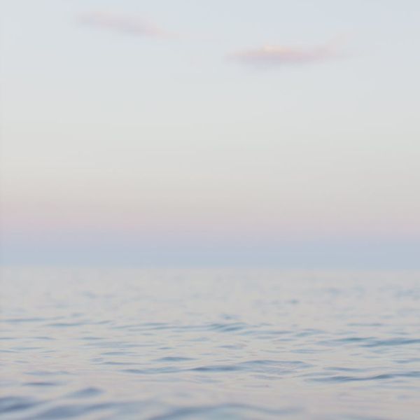 Woman meditating peacefully with a soft blue glow around her.